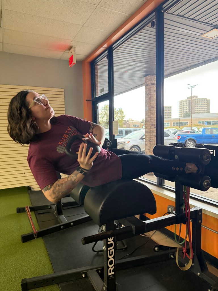 A woman performs an exercise at the gym with a kettlebell